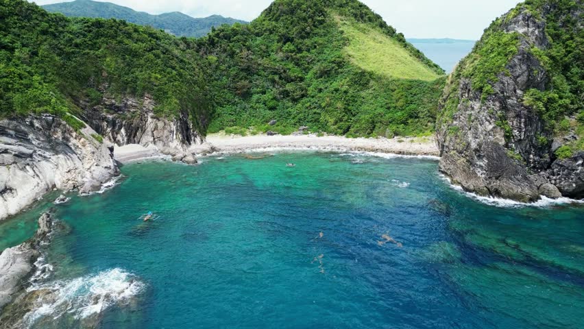 Stunning Aerial View of tropical island cove with turquoise ocean waters, lush jungles and rock formations. Catanduanes, Philippines. Royalty-Free Stock Footage #1103397699