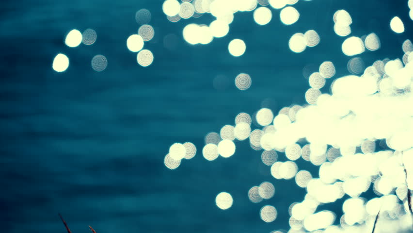 Blurred sea water background. Sun reflects and sparkles on waves with bokeh lights.