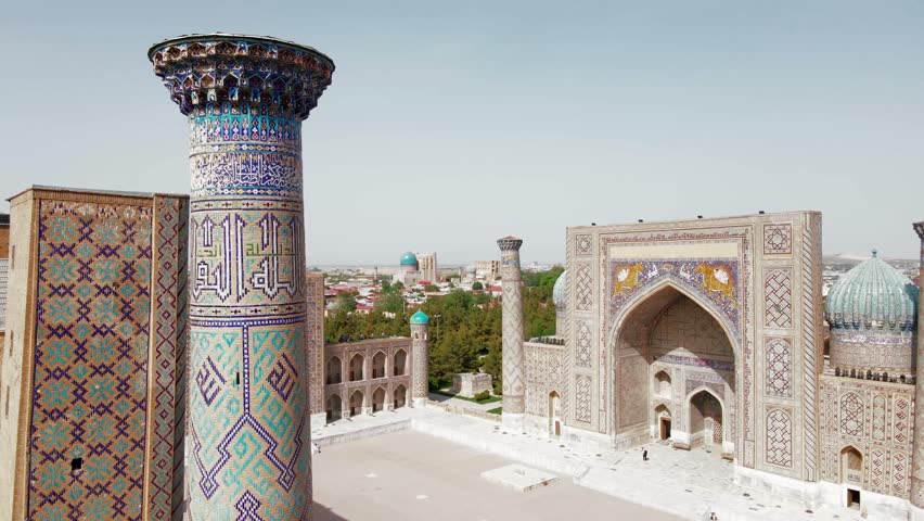 Samarkand, Uzbekistan aerial view of The Registan Square. Ulugh Beg Madrasah and the Tilya-Kori Madrasah a popular tourist attraction of Central Asia. Royalty-Free Stock Footage #1103398595