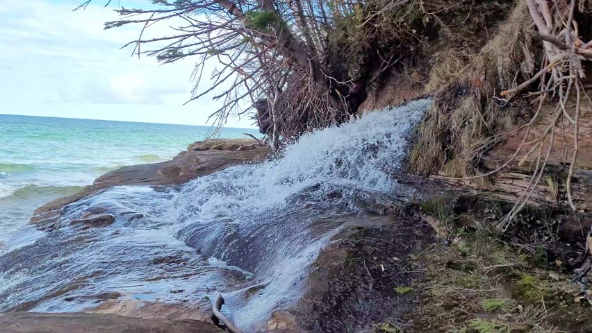 Slow motion view of Elliot Falls and waves of Lake Superior on Miner