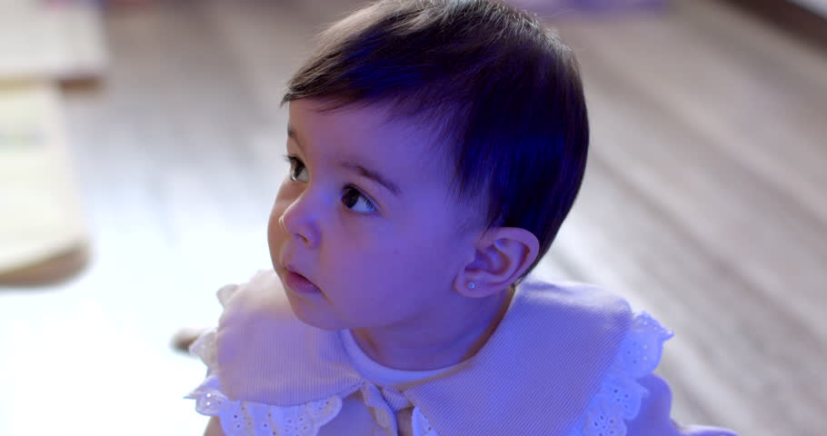 A portrait of a child in the light flashing blue and red. Police work to find a missing child. Light of anxiety. She sucks her finger the sucking reflex of a baby.