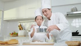 Asian father teaching little son preparing dough, baking cookies in kitchen wearing chef costume enjoying weekend playtime cooking baking. Happy family concept - Powered by Shutterstock - Get 15% off with code: PIKWIZARD15