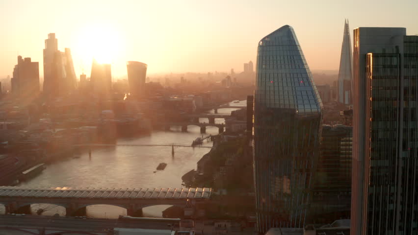 Aerial slider shot over the river Thames looking towards city of London at sunrise