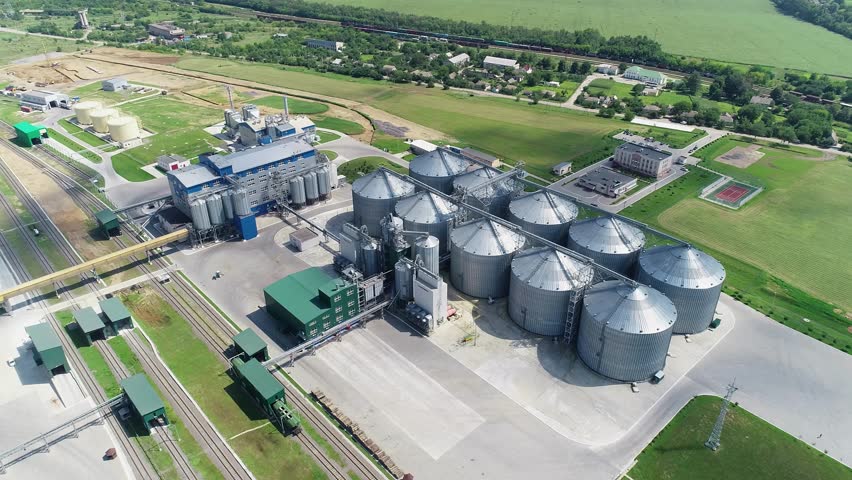 Large silver granary. Storage of grain. Factory for the production of mixed fodders. Steel grain elevators. Agriculture Industry. Aerial view.