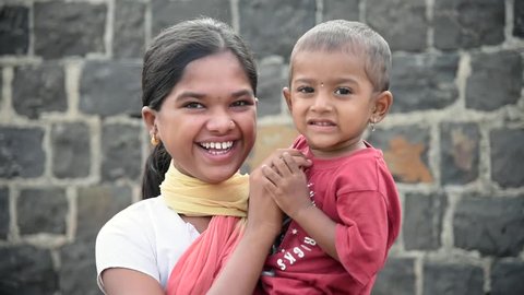 MAHARASHTRA, INDIA July 11, 2015: rural village girl with baby boy closeup, July 11, 2015, Salunkwadi, Ambajogai, Beed, Maharashtra, India