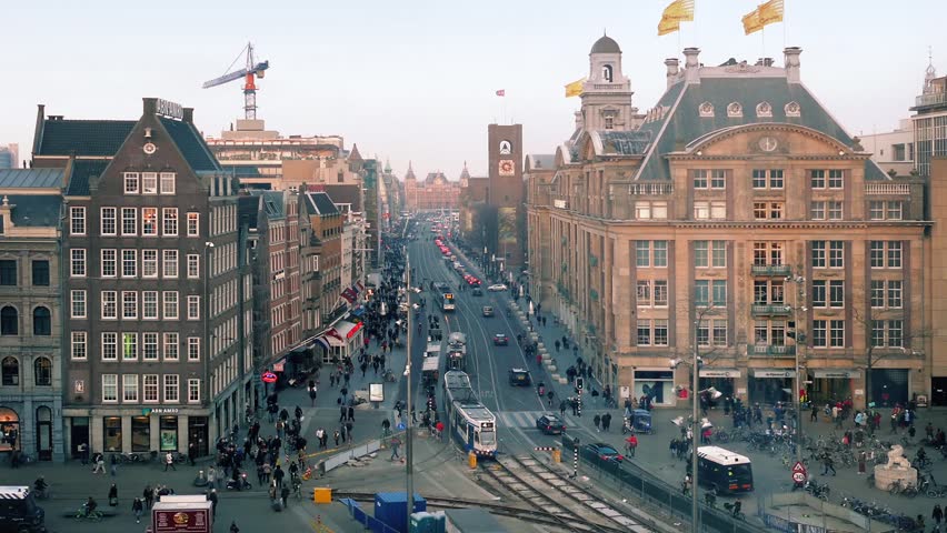 Busy Amsterdam City Centre With Passing Trams
