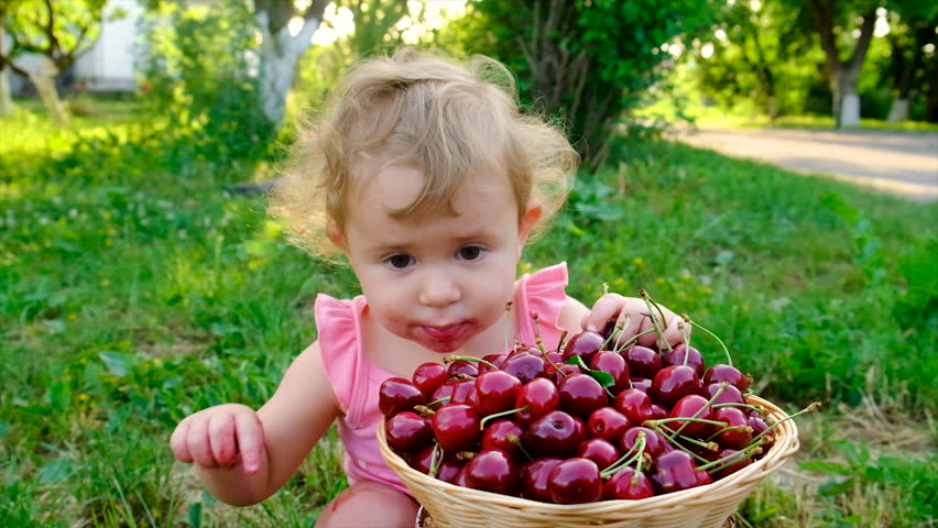 The child eats cherries in the garden. Selective focus. Kid. Royalty-Free Stock Footage #1103420753