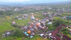 Drone shot of air balloon festival in Indonesia like the one in Cappadocia. Tourist attraction event - High altitude 4K Aerial view