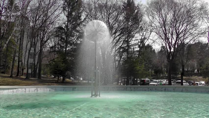 Large swimming pool filled with water with a working fountain
