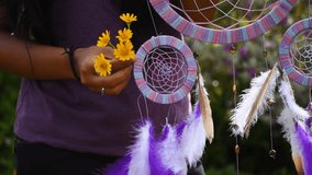 Hippie Indian Woman with flowers in hand holding dreamcatcher in garden. Ritual decoration for good dreaming. Atmospheric mood and spirituality concept - Powered by Shutterstock - Get 15% off with code: PIKWIZARD15