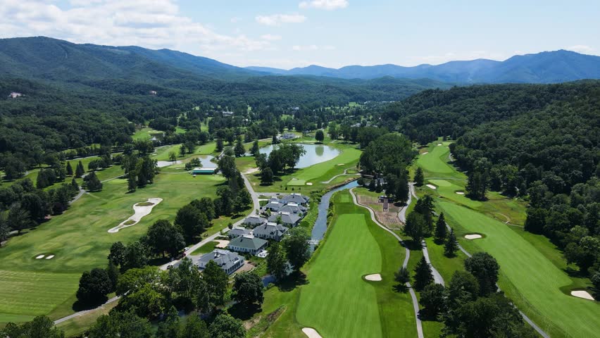 Aerial rotating parallax shot over The Greenbrier golf courses with mountains in the background during summer. Royalty-Free Stock Footage #1103432259