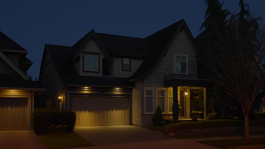 Establishing shot of two story stucco luxury house with garage door, big tree and nice landscape at night in Vancouver, Canada, North America. Night time on Apr 2023. ProRes 422 HQ. Royalty-Free Stock Footage #1103435625