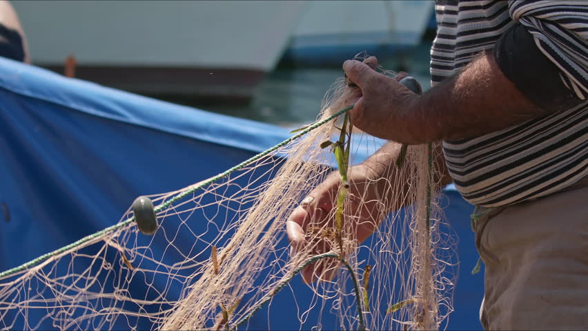 Fisherman Cleaning Their Nets In The Sea Village Footage. Royalty-Free Stock Footage #1103438035