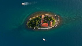 A breathtaking aerial view of the Catholic monastery of Saint George in the Bay of Kotor, Montenegro. Shot on a drone in slow-motion, the footage captures the intricate architecture and stunning