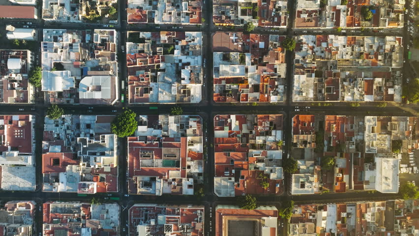 Aerial view of typical buildings of Guadalajara cityscape. Example of famous residential urban grid in scenic gentle golden sunlight. Mexico aerial drone scenic latin city streets with red roofs 4K