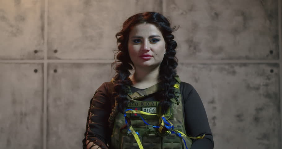 The veteran woman in uniform, alongside her fellow soldiers, stands at a memorial honoring those who fought for Ukraine