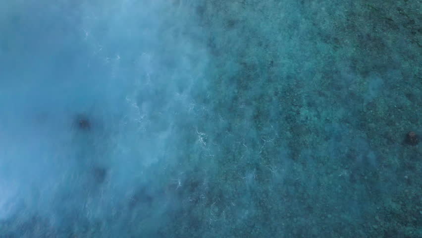 Beautiful texture of small ocean wave passing over coral reef . Aerial top view footage of fabulous sea tide. Drone filming waves with small amount of energy on clear water in Indian ocean. low tide.  | Shutterstock HD Video #1103447995