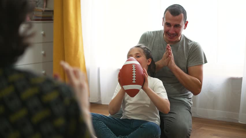 Happy family.Child with his father plays with ball at home.Fun home game. Education in kindergarten.Children dream in game.Family happiness at home. Rugby ball. American football at home. Kindergarten Royalty-Free Stock Footage #1103449207