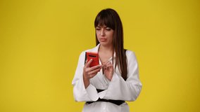 4k video of one woman who talking smugly on the phone over yellow background.