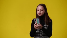 4k video of woman making selfie with her phone on yellow background.