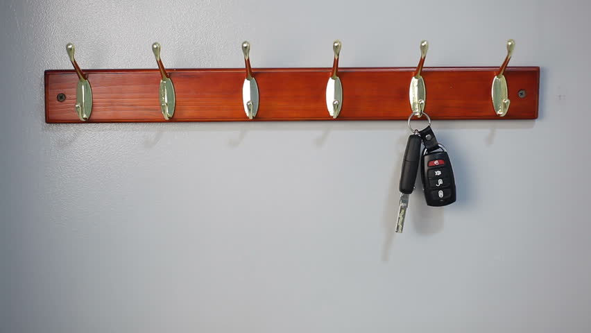 A man takes the keys to the ignition of the car from the hanger. Keys with an alarm key fob hang on a hanger. Royalty-Free Stock Footage #1103453695
