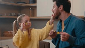 Caucasian father with little daughter at home kitchen cooking eating together child girl kid feed dad with cucumber slice daddy joking pretend feeding baby deceive cheat fooling around happy family - Powered by Shutterstock - Get 15% off with code: PIKWIZARD15