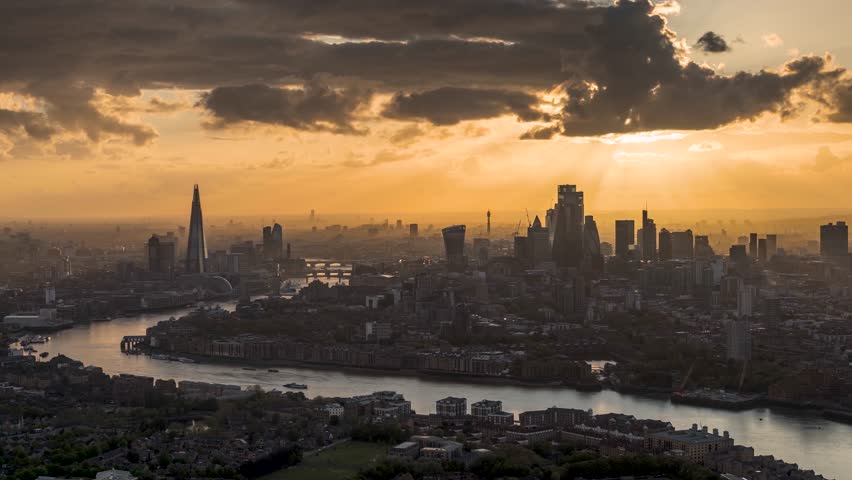 A beautiful sunset to night time lapse view of the modern skyline of London, England, with sunlight om the skyscrapers and rain coming in during evening Royalty-Free Stock Footage #1103454841