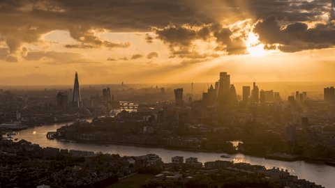 A beautiful sunset to night time lapse view of the modern skyline of London, England, with sunlight om the skyscrapers and rain coming in during evening Adlı Stok Video