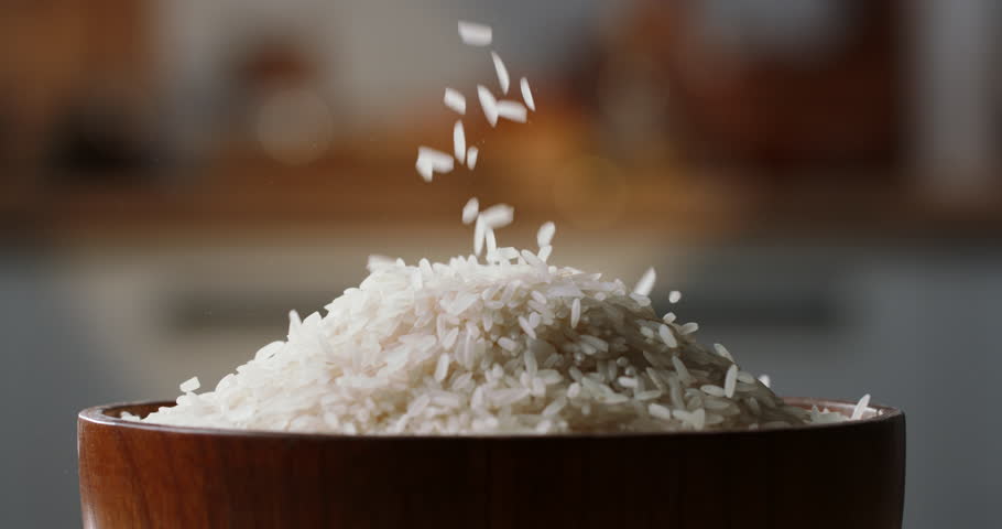 White rice poured drop down fill almost full wooden bowl, close up, organic asian indian japanese food. High-quality 4k horizontal footage slow motion Royalty-Free Stock Footage #1103459325