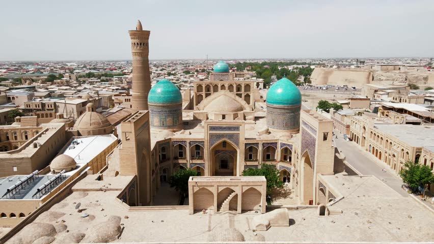 Bukhara, Uzbekistan Aerial view of Kalan Minaret Emir and Alim Khan madrasah of Po-i-Kalan (Poi Kalan) - islamic religious complex Royalty-Free Stock Footage #1103466213
