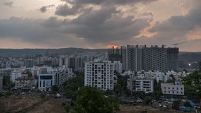 Beautiful golden hour sunset and Day to Night time lapse of aerial cityscape view from a hill, Metro city, Maharashtra, India