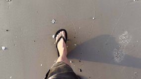Feet in flip flops walking on a sandy beach - Powered by Shutterstock - Get 15% off with code: PIKWIZARD15