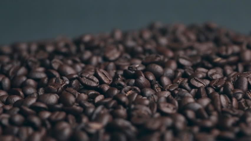 Coffee beans drop on table close up texture background. bland nature excellent taste. Drink coffee in morning afternoon and evening. Quality seeds are suitable for drinkin.