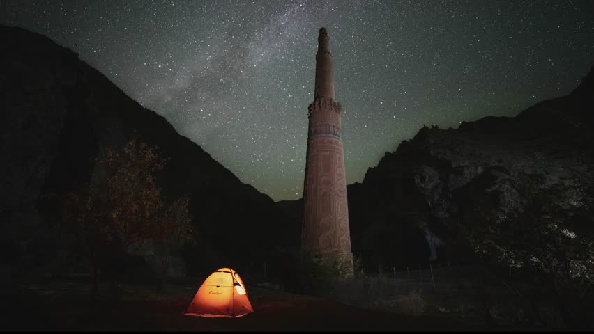 Night timelapse of starry sky over tent by Minaret of Jam, Afghanistan