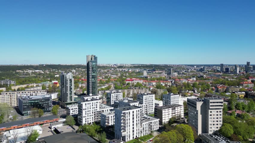 Aerial camera view of spring in Vilnius, Lithuania. Moving towards drone shot of panoramic city view. Green capital. Urbanistic. Modern area. Royalty-Free Stock Footage #1103478885