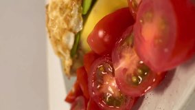 Beautiful breakfast close up video. Fried eggs, avocado toast, tomatoes and blueberries on the plate. Healthy food