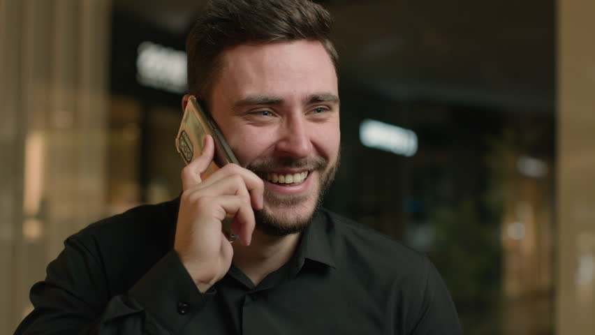 Excited Caucasian man businessman speak phone in office company shocked male executive worker talk cellphone mobile conversation call friend listen good news happy laughing rejoice surprise fun laugh