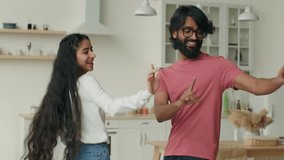 Arabian husband dance with indian wife happy carefree ethnic couple dancers dancing in home kitchen listen music smiling woman girl and man guy have fun celebrate weekend relocation to rented house - Powered by Shutterstock - Get 15% off with code: PIKWIZARD15