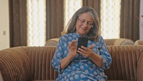 Happy Indian old woman using mobile phone - Powered by Shutterstock - Get 15% off with code: PIKWIZARD15