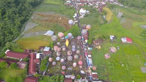 Aerial view of Colorful air balloon floating on the air with view of rural landscape. Air balloon festival held in Indonesia like the one in Cappadocia. Wonosobo, Central Java - 4K Aerial View