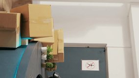 Asian manager asking courier to sign shipment report, discussing orders details in modern boutique. African american deliveryman bringing cardboard boxes to clothing store. Fashion concept