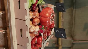 Vertical video: Boxes filled with organic fruits and vegetables placed on stand, fresh natural farming produce at outdoors food fair. Empty local farmers market counter with raw colorful healthy