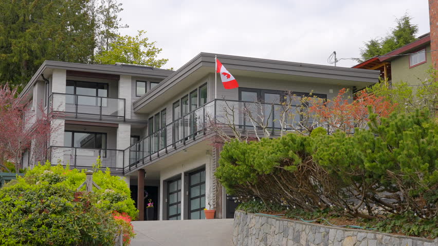 Establishing shot of two story stucco luxury house with garage door, big tree and nice spring blossom landscape in Vancouver, Canada, North America. Day time on Apr 2023. ProRes 422 HQ.