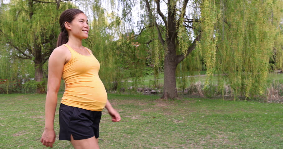 Prenatal workout pregnant woman walking outside in park living an active lifestyle during pregnancy. Daily walks during summer outdoor Royalty-Free Stock Footage #1103506167