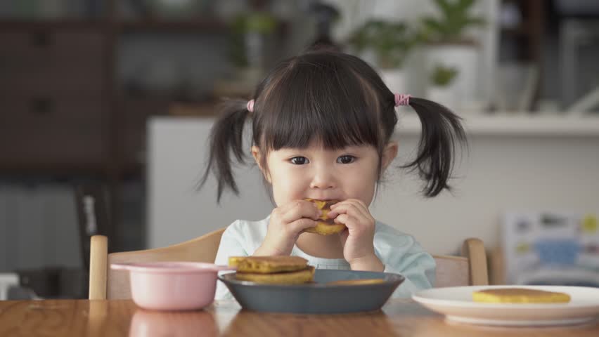 Asian child eating pancakes at home Royalty-Free Stock Footage #1103509197