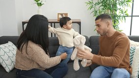 Couple and son playing with teddy bear sitting on sofa at home - Powered by Shutterstock - Get 15% off with code: PIKWIZARD15