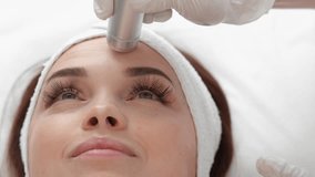 Cosmetology mesotherapy for facial rejuvenation. A professional cosmetologist helps to restore the health and appearance of facial skin in a beauty salon. Video close-up. Hardware modern cosmetology