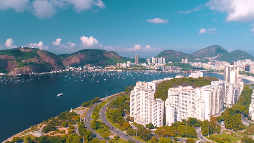 RIO DE JANEIRO, BRASIL - MAY, 2023: Drone aerial view of of Botafogo beach and district and Guanabara Bay. Modern and historical buildings on the shore on background at sunny day from above.