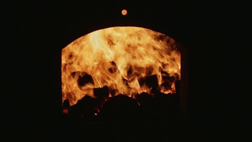 A closeup of charcoal burning inside the factory kiln or industrial fire kiln.hot fire and charcoal.soap factory.furnace fire