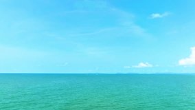 A drone fly through the endless expanse of blue sky, casting its watchful eye over the shimmering expanse of the vast sea below, a world of endless blue. Natural background footage. Aerial view. 4K
